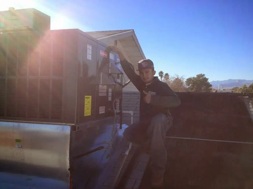 HVAC technician performing AC Tune-Up on a rooftop unit in Rosemount