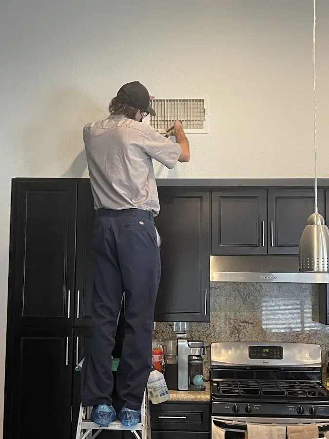 Technician inspecting an air vent during HVAC service in Rosemount